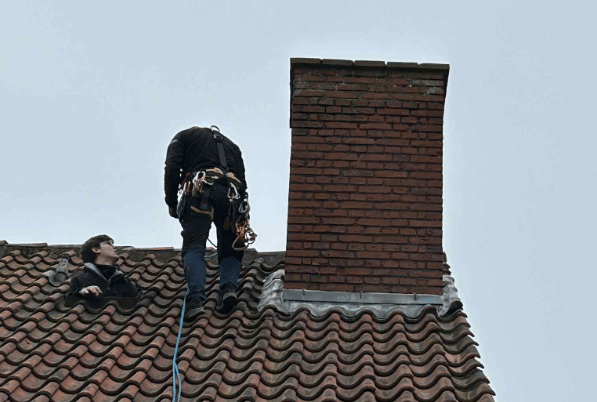 Vedligeholdelse og reparation af et tegltag med reb og sele i København